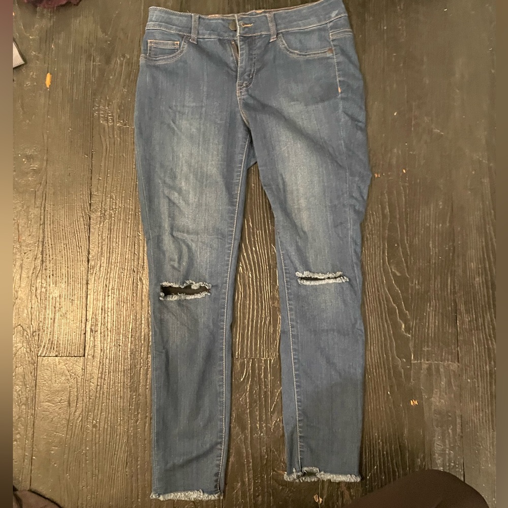 Skinny jeans with holes in knees and frayed at the bottom